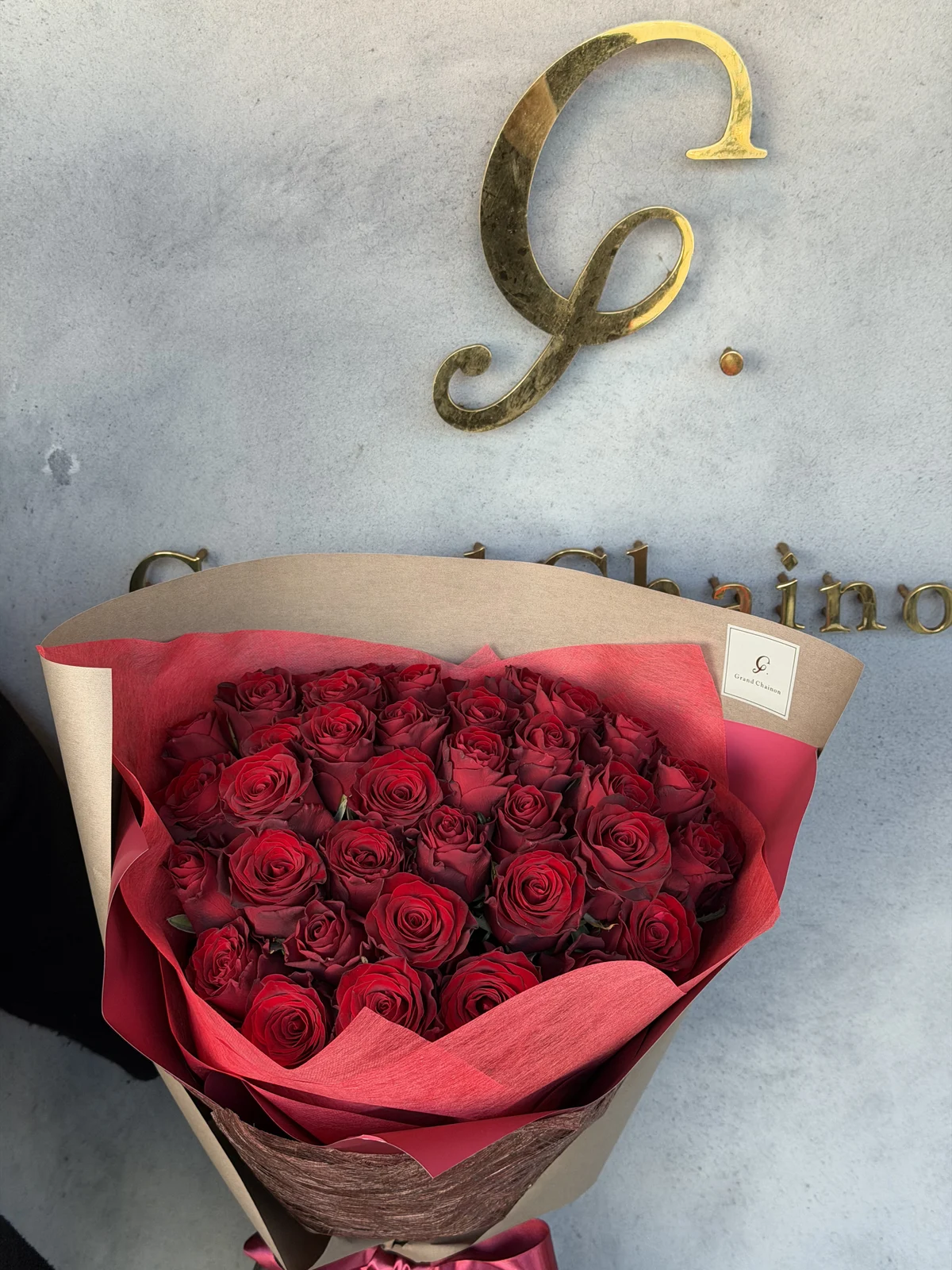 赤とブラウンのラッピングに包まれた赤薔薇の花束